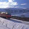 Tog som kjører gjennom vinterland langs ranfjorden